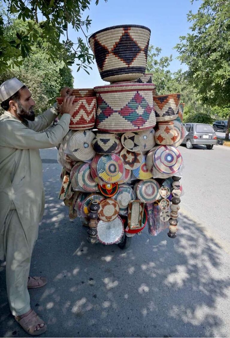 A street vendor displaying hand-made domestic use items to attract customers at roadside in F-10 Markaz