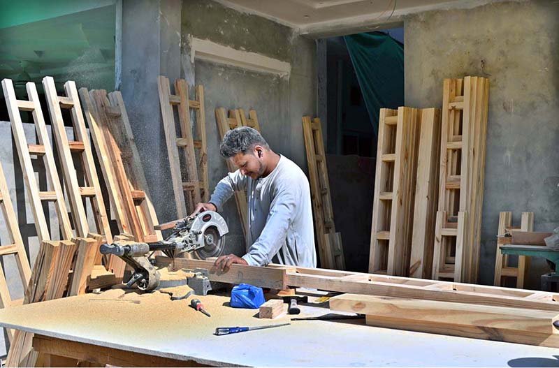 A carpenter is busy cutting wood to prepare door frames for a house at a construction site