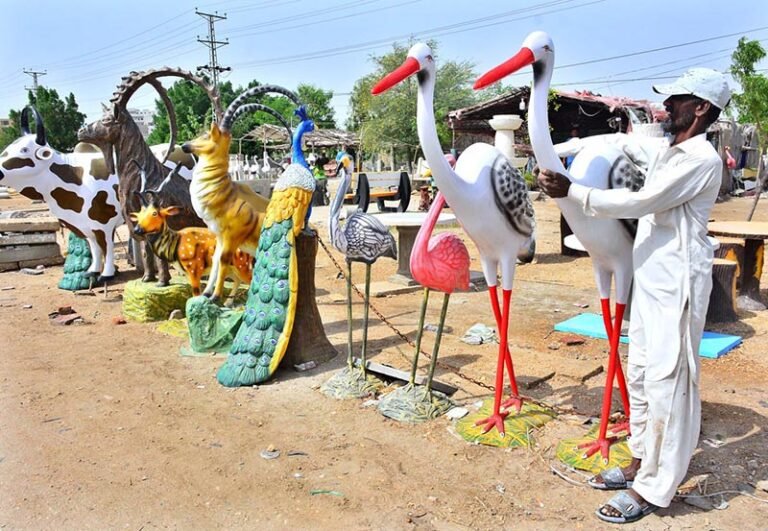 A vendor displaying decorative statues of different animals and birds to attract the customers at Qasimabad