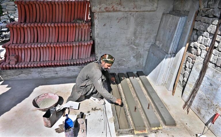 A worker prepares tuff tiles and other cemented items at his workplace in Pindora.