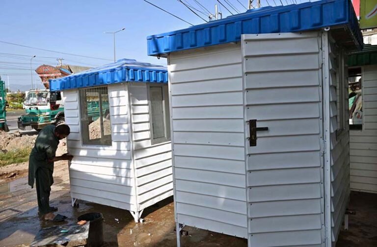 A painter gives the finishing touches to security guards’ cabins at his workshop in the federal capital