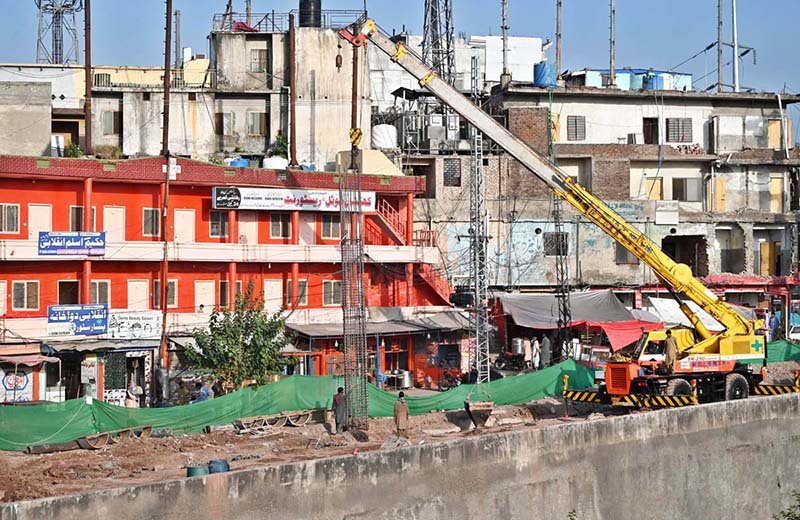 Heavy machinery, including excavators and cranes, is deployed at the service road construction site along the Expressway as development work continues to improve the road infrastructure in the Federal Capital