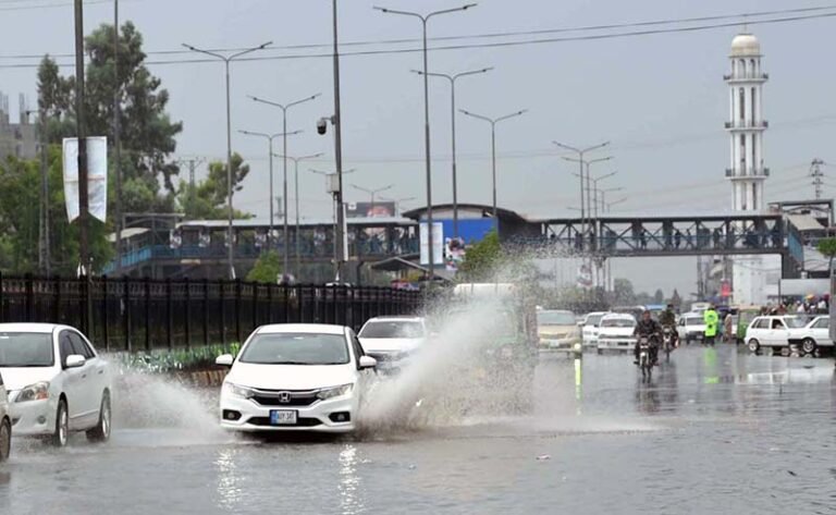 Vehicles passing through rain water accumulated on a University Road following heavy rainfall in the Provincial Capital.