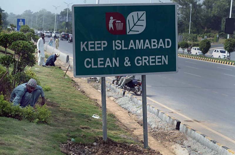 CDA workers tend to the green belt along Srinagar Highway in the Federal Capital.