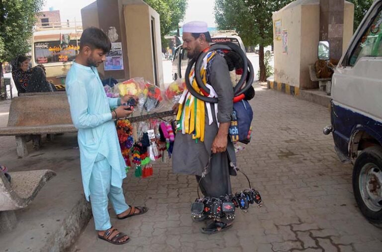 A customer purchases decorative items for vehicles at Lari Adda.