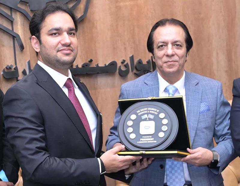 President Chamber of Commerce, Khawar Hussain Sapal, is presenting a souvenir to Provincial Minister for Energy, Sports, and Youth Affairs, Faisal Ayub Khokhar, at SCCI