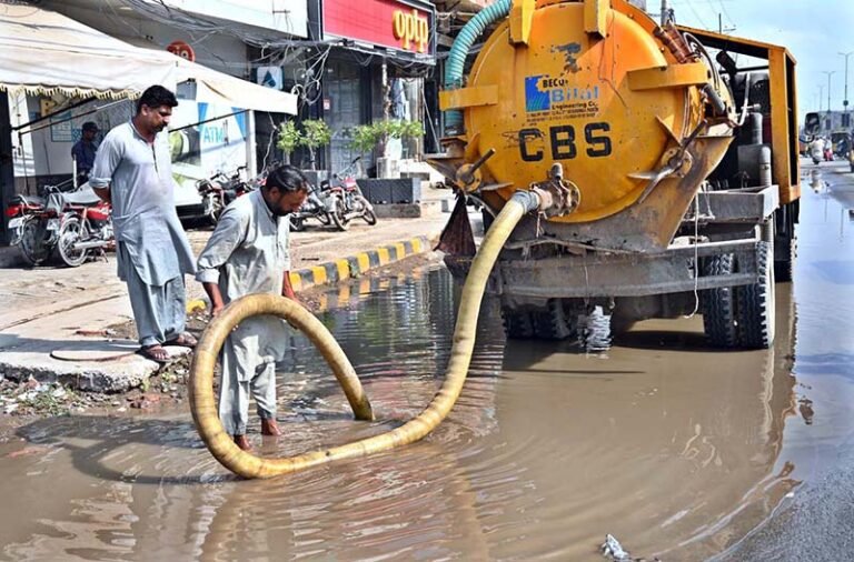 Cantonment Board workers clear accumulated water to ensure proper drainage to facilitate commuters on College Road.