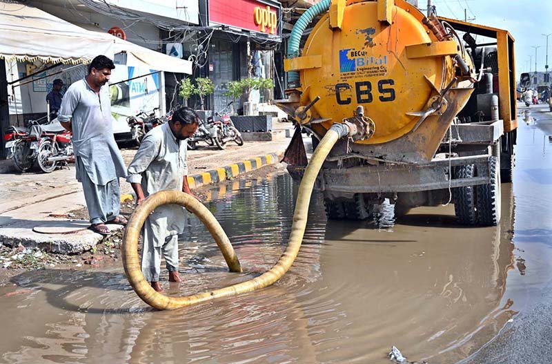 Cantonment Board workers clear accumulated water to ensure proper drainage to facilitate commuters on College Road.