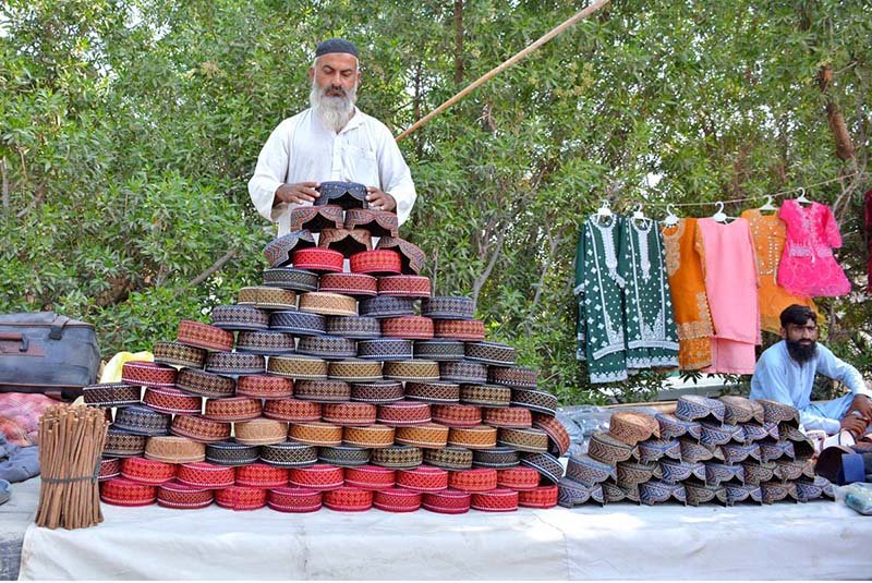 A roadside vendor displays caps to attract customers at his stall