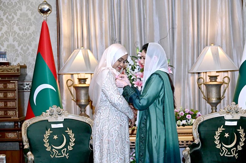 First Lady Bibi Asifa Bhutto Zardari, MNA, pins a pink ribbon on the dress of First Lady of the Republic of Maldives, Madam Sajidha Mohamed, at Aiwan-e-Sadr