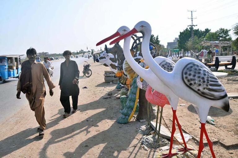 A vendor is displaying decorative statues representing different animals and birds to attract customers at Qasimabad Road.