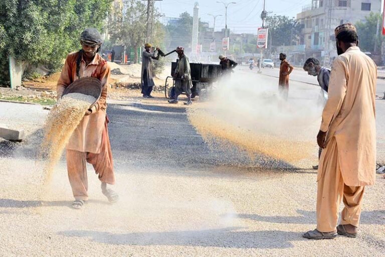 Labourers are busy construction work of road at Latifabad Unit Number 09 during development work in the city
