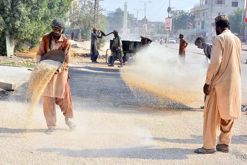 Labourers are busy construction work of road at Latifabad Unit Number 09 during development work in the city