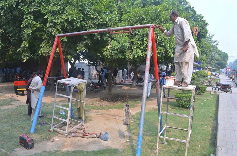 Workers busy in maintenance work of a swing installed near Divisional Public School at Club Road