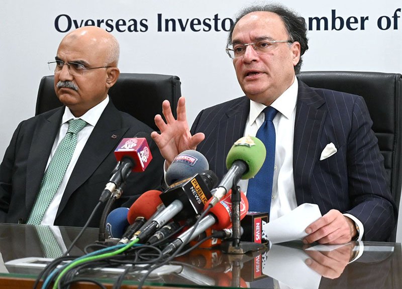 Federal Minister for Finance and Revenue Senator Muhammad Aurangzeb, accompanied by Adviser to the Finance Minister Khurram Schehzad, talks to media persons after a meeting at the Overseas Investors Chamber of Commerce and Industry (OICCI) office