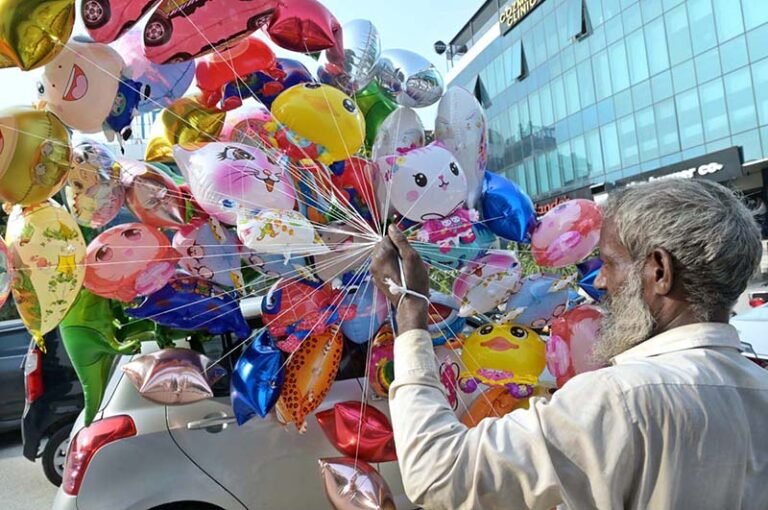A vendor selling colorful helium-filled different cartoon characters at a roadside stall in F-11 Markaz