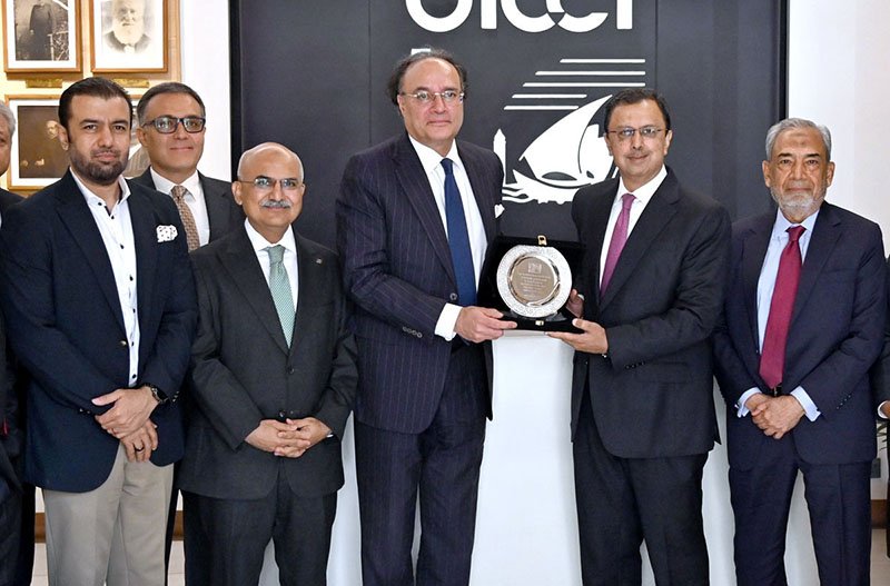 Federal Minister for Finance and Revenue Senator Muhammad Aurangzeb receives a souvenir during a meeting at the Overseas Investors Chamber of Commerce and Industry (OICCI) office