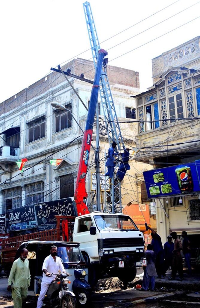 HESCO workers busy in installing new electric pole with help of crane at outside court road