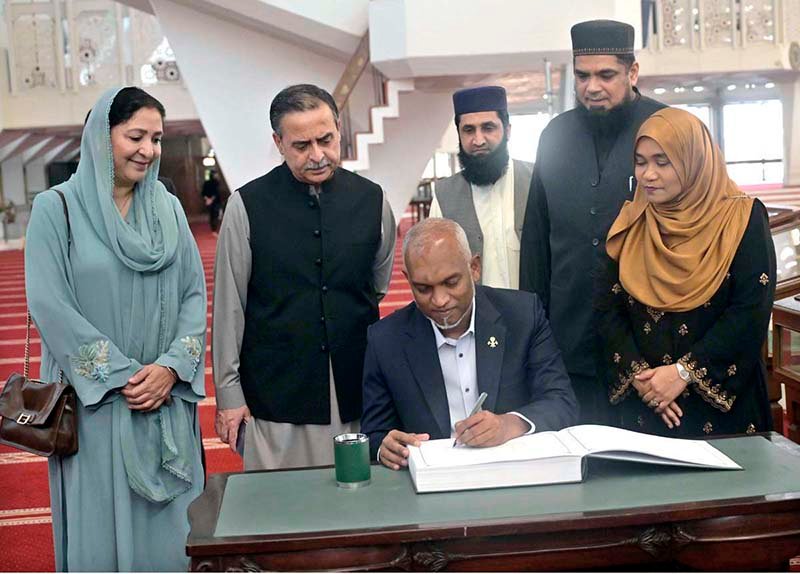President of the Republic of Maldives Dr. Mohamed Muizzu writing his remarks in the visitors' book during his visit to the Faisal Mosque