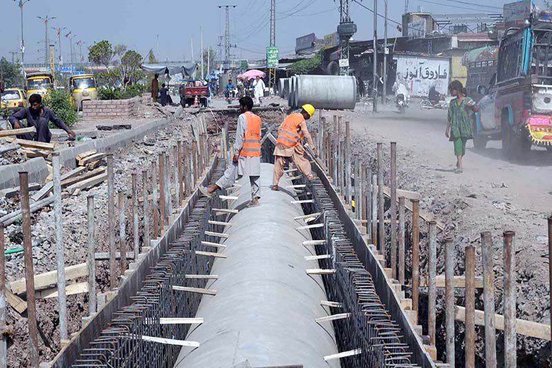 Workers install drainage pipes along Ring Road as part of ongoing development work to improve the city’s drainage system