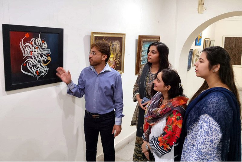 Visitors view calligraphy artworks at an exhibition organized by the Arts and Culture Forum (ACF) and the University of Home Economics in connection with the International Conference on Art and Design at Coopera Art Gallery, Mall Road
