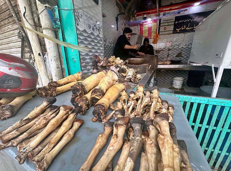 A vendor cutting paye (cow trotters) for customers at Bani Market.