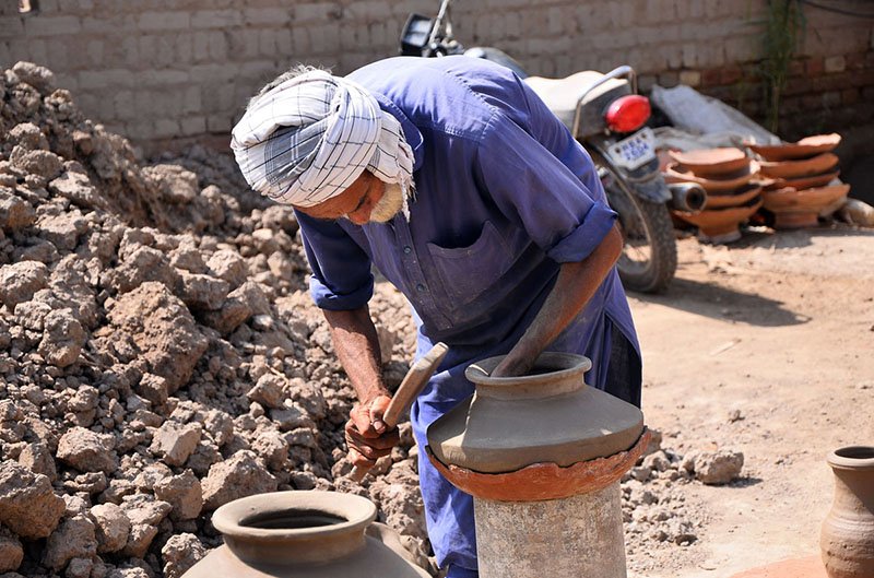 A worker preparing clay-made pitchers at his work place in kumharpara jamshoro road.