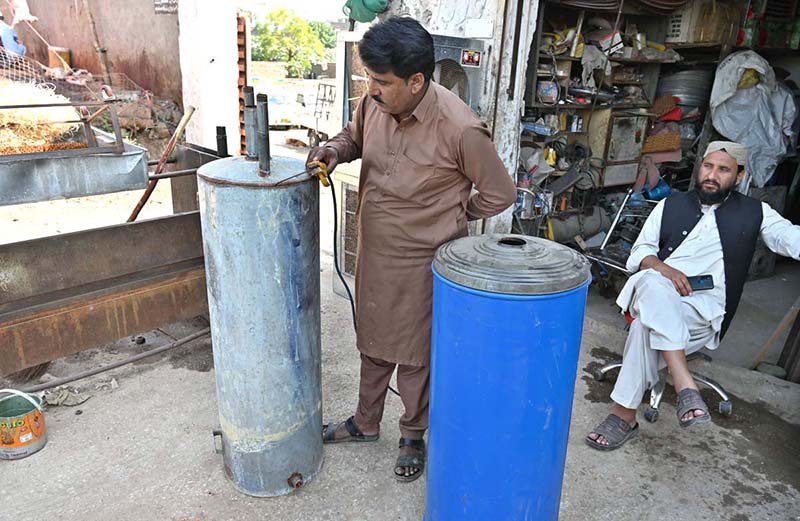 A worker is busy repairing a gas geyser at his workplace in the Federal Capital