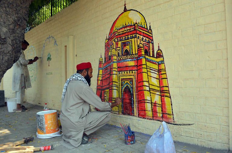 An artist paints a mural depicting the shrine of Hazrat Bahauddin Zakariya on a wall at the historic Mission Hospital in Cantt to enhance the beauty of the city