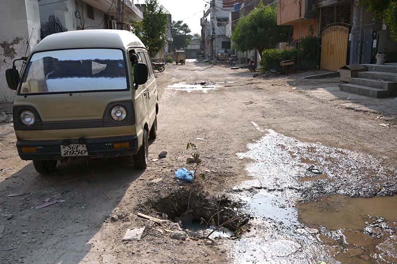 An uncovered open manhole poses a safety hazard to residents in Kachi Basti, requiring the attention of the concerned authorities