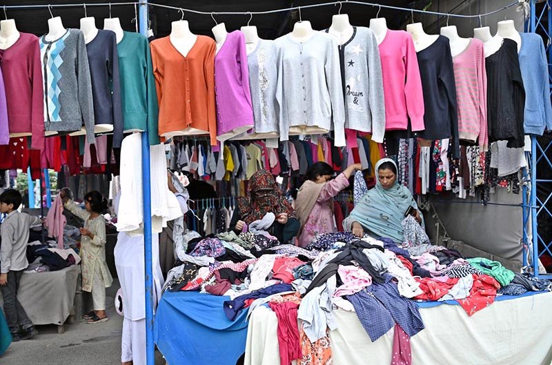 Women select and purchase used clothes at the I-9 weekly bazaar in the Federal Capital