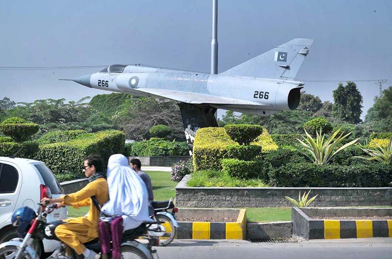 A Pakistan Air Force aircraft displayed along a road in Hayatabad as motorists pass by in the provincial capital
