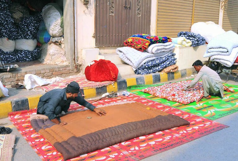 Workers stitch quilts at their workplace as demand increases with the onset of the winter season.