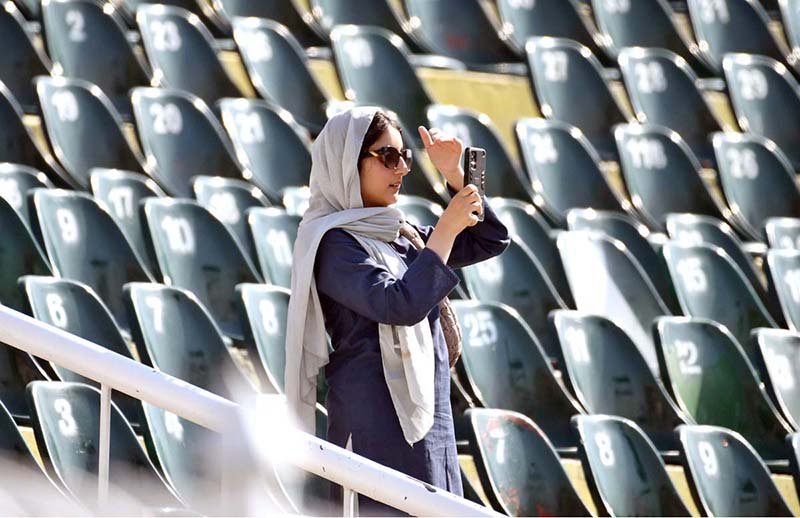 A spectator capturing the moment with her cell phone during the ODI Tri-Nation Series cricket match between England and Sri Lanka at Rawalpindi Cricket Stadium