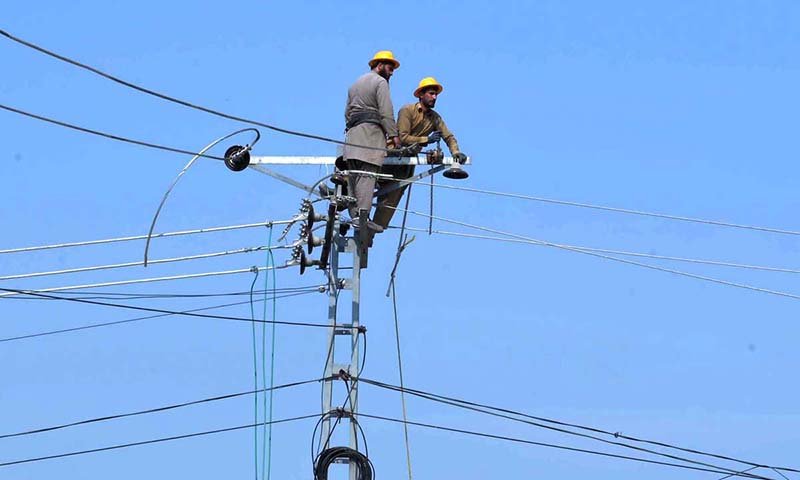 PESCO line workers carry out maintenance work on a power transmission pole along Ring Road