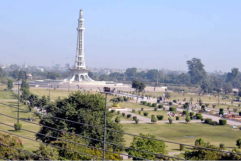 A view of the historic Minar-e-Pakistan at Greater Iqbal Park as visitors enjoy a pleasant day in the park.