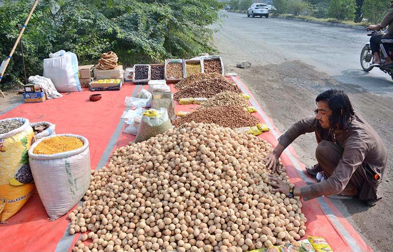 A vendor is displaying and selling dry fruit at his roadside setup
