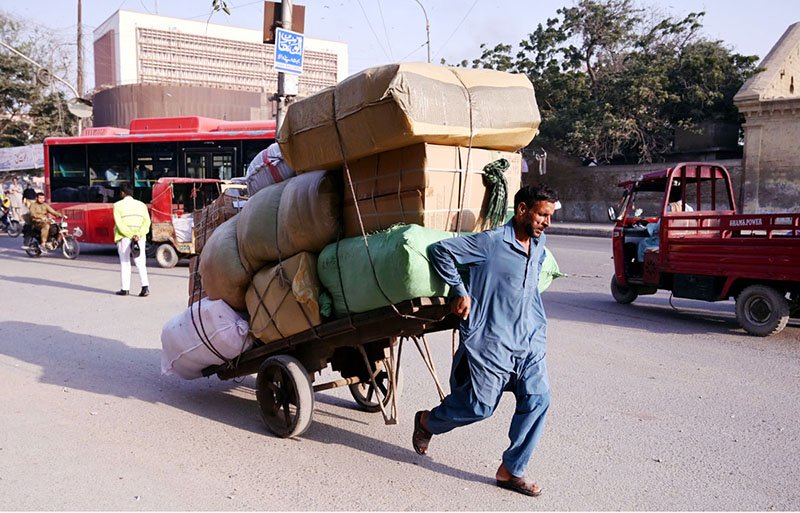 A labourer pushes a loaded cart in the Tower area of the city