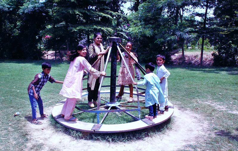 Children enjoying swings at a park in the city.