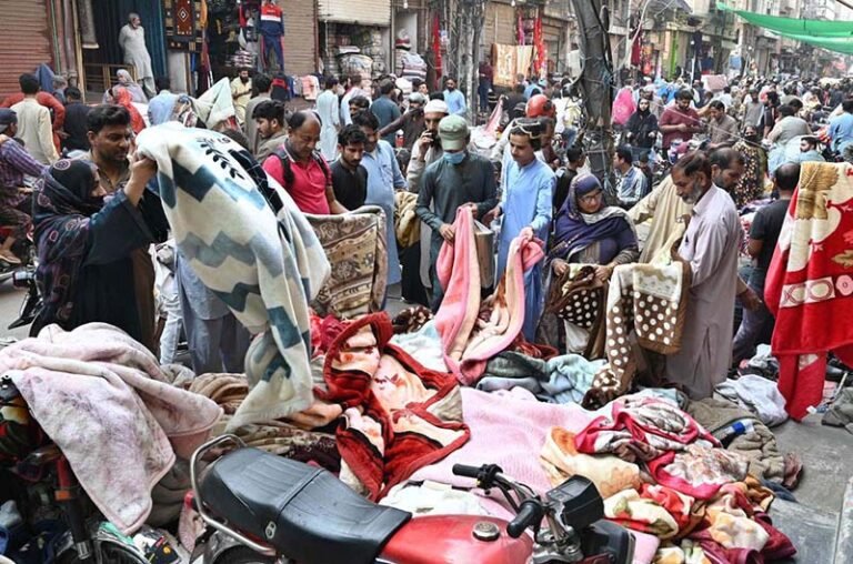 People buy blankets at a Landa Bazaar (second-hand goods market) as the weather turns colder