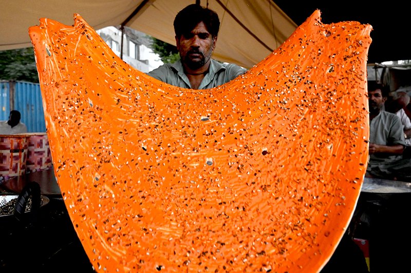 A vendor preparing the traditional food item Katlama (traditional food like pizza) to the customer on the roadside setup in the Provincial Capital.