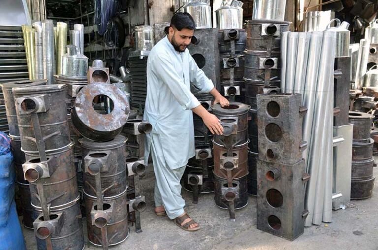 Man displaying traditional stoves as per increased demand in winter season at Surajganj Bazaar