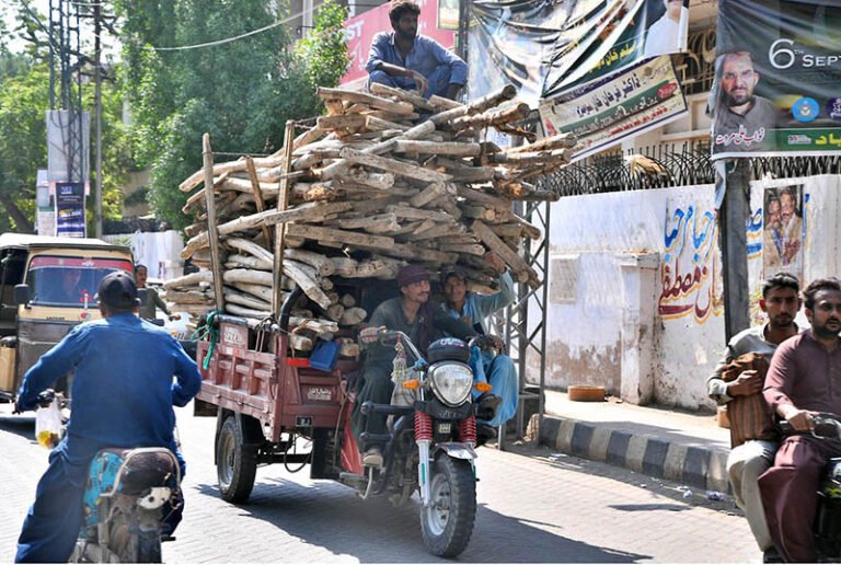 A tricycle loader on its way, loaded with shuttering material at GPO Road