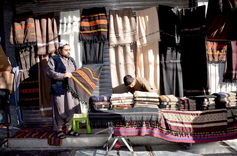 A man purchase warm shawls at Liaquat Bazaar as the winter season approaches.