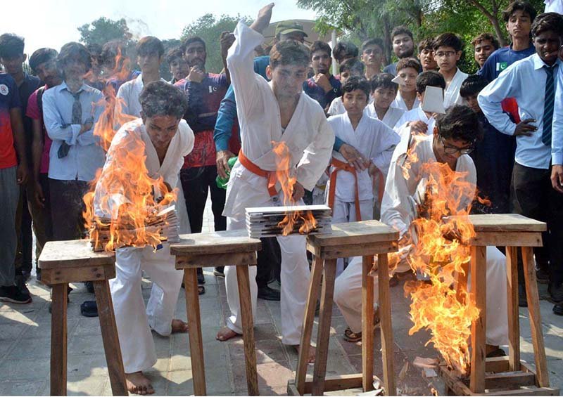 Martial arts players demonstrate their skills to break fire bricks during the opening ceremony of the Inter-Collegiate Boys’ Hockey Tournament at the Astroturf Hockey Stadium, Mela Mandi