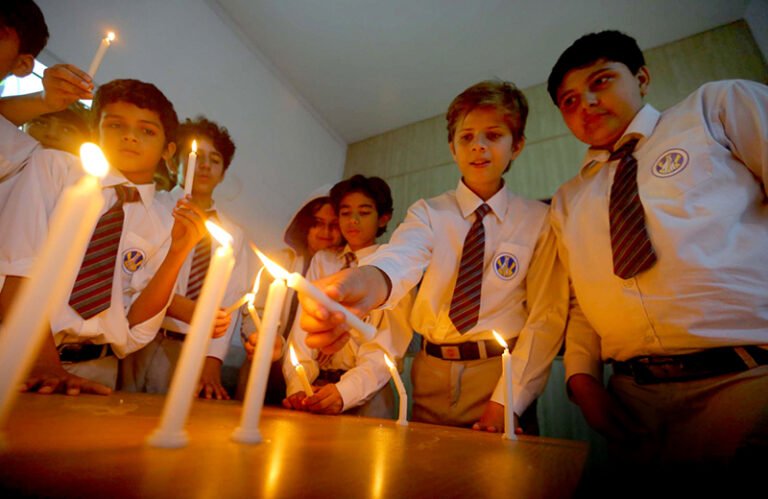 Students light candles during a vigil to pay tribute to the martyrs of the Dir school tragedy.