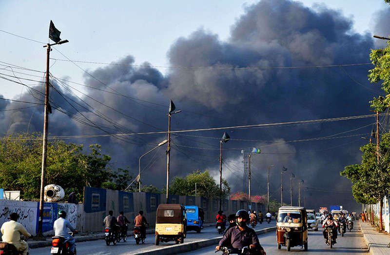 Thick plumes of black smoke rise into the sky after a fire erupted in a factory at Site industrial area