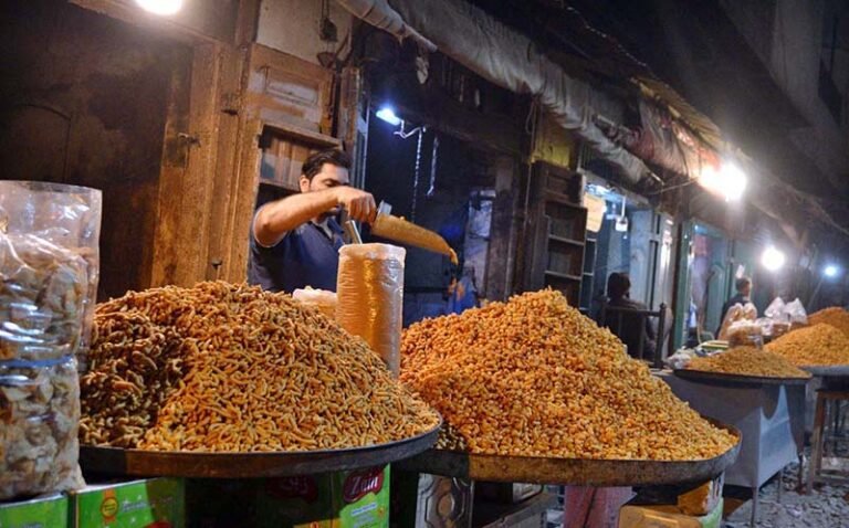 A shopkeeper decorates different types of ‘besan ki bondiyas’ to attract customers in Ghala Mandi.