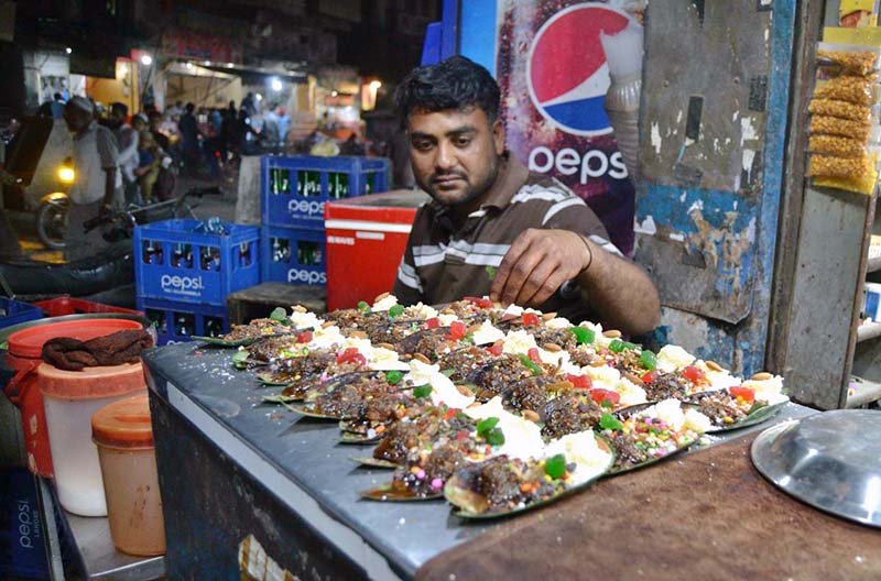 A paan vendor prepares sweet paan with fennel seeds, cardamom and other aromatic ingredients for customers at Lakshmi Chowk.
