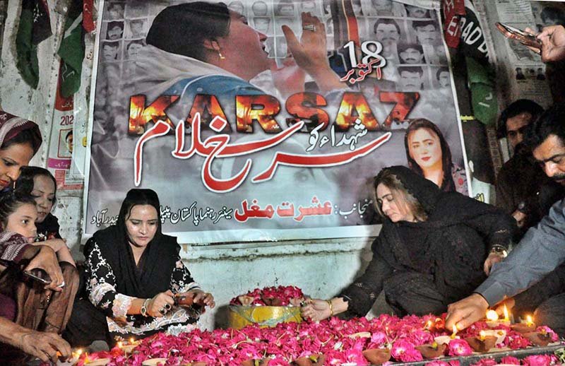 Pakistan People’s Party (PPP) women workers light lamps in memory of the Karsaz tragedy martyrs outside a press club
